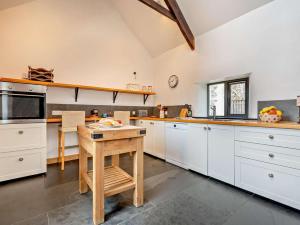 een keuken met witte kasten en een houten tafel bij 2 Bed in Bude oc-64088 in Marhamchurch