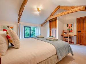 een slaapkamer met een groot bed en een bureau bij 2 Bed in Bude oc-64088 in Marhamchurch