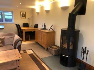 a living room with a wood stove in a room at The Annexe at the Cedars in South Brent