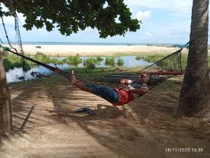 - un homme dormant dans un hamac sur une plage dans l'établissement Shalom Beach Villa, à Kalkudah
