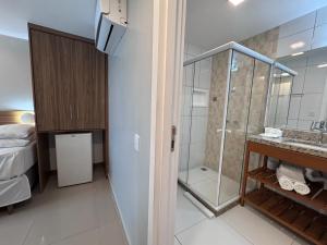 ein Badezimmer mit Dusche und Waschbecken und ein Bett in der Unterkunft Pousada Boutique do lazer in Cabo Frio + 38 Fotos