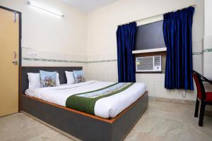 a bedroom with a large bed with blue curtains at Hotel #Blue Moon# Front Of Bhubaneswar Railway Station in Bhubaneshwar