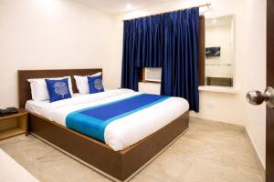a bedroom with a large bed with blue pillows at Hotel #Blue Moon# Front Of Bhubaneswar Railway Station in Bhubaneshwar +17 photos