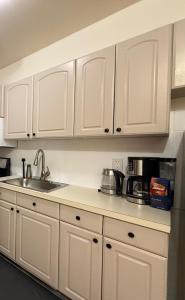 una cucina con mobili bianchi e un lavandino di Budget Comfortable Apartments a New York