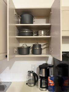 una cucina con pentole e padelle adagiate sugli scaffali di Budget Comfortable Apartments a New York