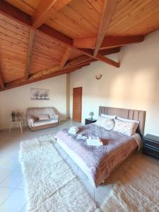 ein Schlafzimmer mit einem großen Bett in einem Zimmer mit Holzdecken in der Unterkunft Konitsa Horizon Villa in Konitsa + 6 Fotos