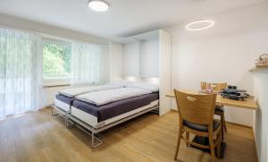 a bedroom with a bed and a desk at Figaro in Leukerbad