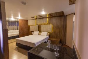a hotel room with a bed and a table at Motel Fascínio (Only Adults) in Cascavel