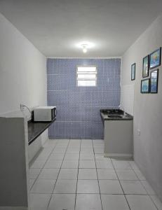 una piccola cucina con lavello e microonde di MarBelo Bertioga Apartamentos e Suítes a Bertioga