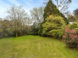 een tuin met bomen, gras en struiken bij Lower Axford Cottage in Callington