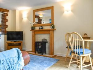 een woonkamer met een open haard en een spiegel bij Lower Axford Cottage in Callington +6 foto's