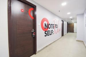 a door in a hallway with a sign on the wall at Hotel O by OYO Crown Aura in kolkata