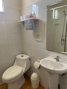 a white bathroom with a toilet and a sink at Loft Tongoy 1 frente al mar in Coquimbo +32 photos