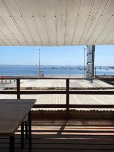 a view of a beach with a table and a bench at Loft Tongoy 1 frente al mar in Coquimbo