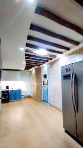 a kitchen with blue cabinets and a stainless steel refrigerator at 3 bedroom Nijma large authentic Moroccan apartment in Tangier