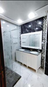 a bathroom with a shower and a sink and a mirror at 3 bedroom Nijma large authentic Moroccan apartment in Tangier