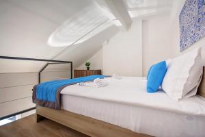 Schlafzimmer mit einem Bett mit blauen und weißen Kissen in der Unterkunft Enjoy Apartments in Sarajevo