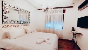 a bedroom with a white bed with a cross on it at 3 bedroom Nijma large authentic Moroccan apartment in Tangier