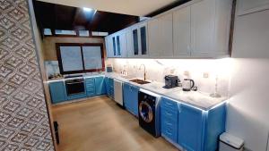 a kitchen with blue cabinets and a washer and dryer at 3 bedroom Nijma large authentic Moroccan apartment in Tangier +7 photos