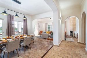 a dining room and living room with a table and chairs at Spacious Villa Swimming Pool by HostWise in Lagoa