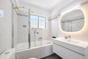 a bathroom with a tub and a sink and a mirror at Andromaches by Verde Apartments in Athens +18 photos