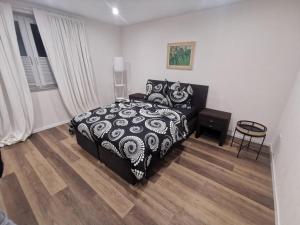 a bedroom with a black and white bed and a wooden floor at NEU! Modernes Wohnen Bad Berleburg in Meckhausen