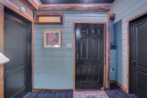 een hal met een zwarte deur en blauwe muren bij Stylish Retro Stay, Columbia House Unit D apts in Somerset +16 foto's