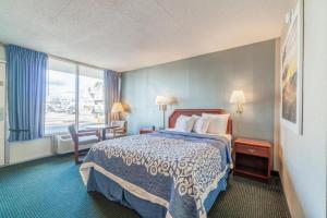 a hotel room with a bed and a table and a window at Ozark Junction Inn in Mountain View