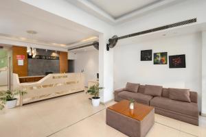 a living room with a couch and a table at The Senate Hotel By Addon Group in Cochin