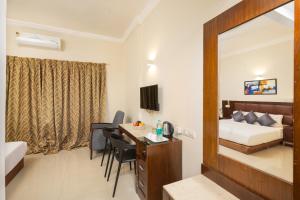 a hotel room with a bed and a desk and a bedroom at The Senate Hotel By Addon Group in Cochin