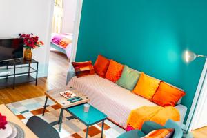 een woonkamer met een bank met kleurrijke kussens bij La Petite Perle de Noisy in Noisy-le-Grand