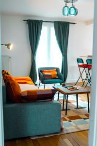 een woonkamer met een bank en een tafel bij La Petite Perle de Noisy in Noisy-le-Grand