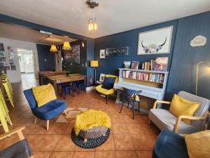 a living room with blue walls and yellow chairs at The Woodquay Hostel in Galway