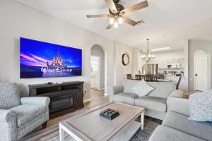 a living room with a couch and a tv at 3BR Windsor Hills Condo Water Park and Skeeball Near Disney No Resort Fees in Orlando