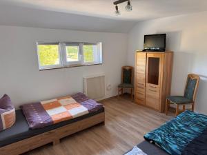 una camera con 2 letti, una TV e un armadio di NEU! Ferienwohnung Elsteraue DG oben a Meuselwitz