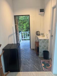 a room with a television and a door to a porch at Little Bailan Retreat - Garden & River Side in Ban Bang Bao +5 photos