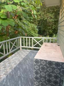 a bench on a porch with a white fence at Little Bailan Retreat - Garden & River Side in Ban Bang Bao