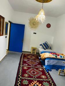 a bedroom with two beds and a red rug at Momo Surf Housse in Wassane +3 photos