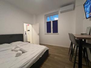 ein Schlafzimmer mit einem Bett und einem Tisch und einem Fernseher in der Unterkunft Unirii Square Studio in Iaşi