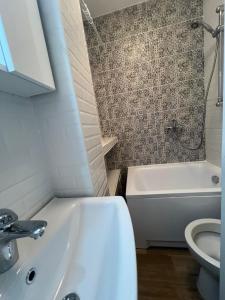 ein Badezimmer mit Waschbecken, Badewanne und Toilette in der Unterkunft Unirii Square Studio in Iaşi