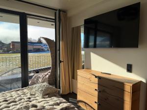 a bedroom with a bed and a tv and a balcony at Alpen Sky Suite Flachau in Flachau