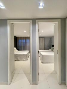 1 Schlafzimmer mit 2 Betten und 2 Spiegeln in der Unterkunft Holanda's Prime in Tambaú