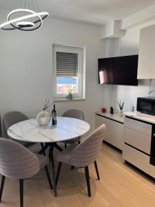eine Küche und ein Esszimmer mit Tisch und Stühlen in der Unterkunft Apartman Ivana Posušje in Posušje