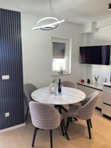 ein Esszimmer mit einem weißen Tisch und Stühlen in der Unterkunft Apartman Ivana Posušje in Posušje