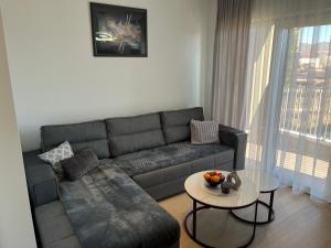 ein Wohnzimmer mit Sofa und Tisch in der Unterkunft Apartman Ivana Posušje in Posušje + 16 Fotos