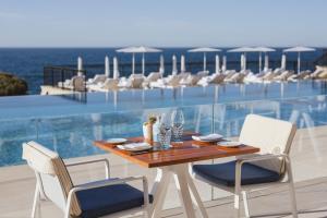 a dining table and chairs on the balcony of a building at Grand-Hôtel du Cap-Ferrat, A Four Seasons Hotel in Saint-Jean-Cap-Ferrat