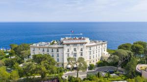 - un bâtiment avec un drapeau au-dessus de l'océan dans l'établissement Grand-Hôtel du Cap-Ferrat, A Four Seasons Hotel, à Saint-Jean-Cap-Ferrat