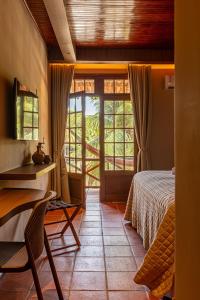 a bedroom with a bed and a table and a window at Hotel Ilha do Marajó by Unna in Soure
