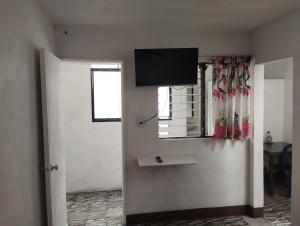 une pièce avec une porte avec une télévision sur le mur dans l'établissement Habita Estudios Laureles, à Medellín