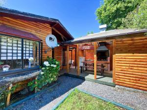 a wooden house with a porch and a bench at Refugio araucano - Lican Ray in Licán Ray